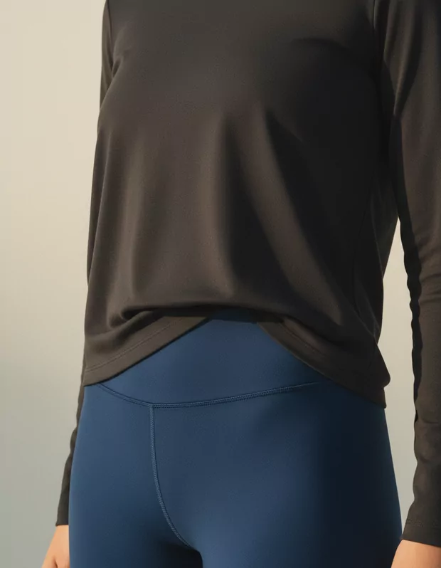 Close detail of a longline top over blue leggings