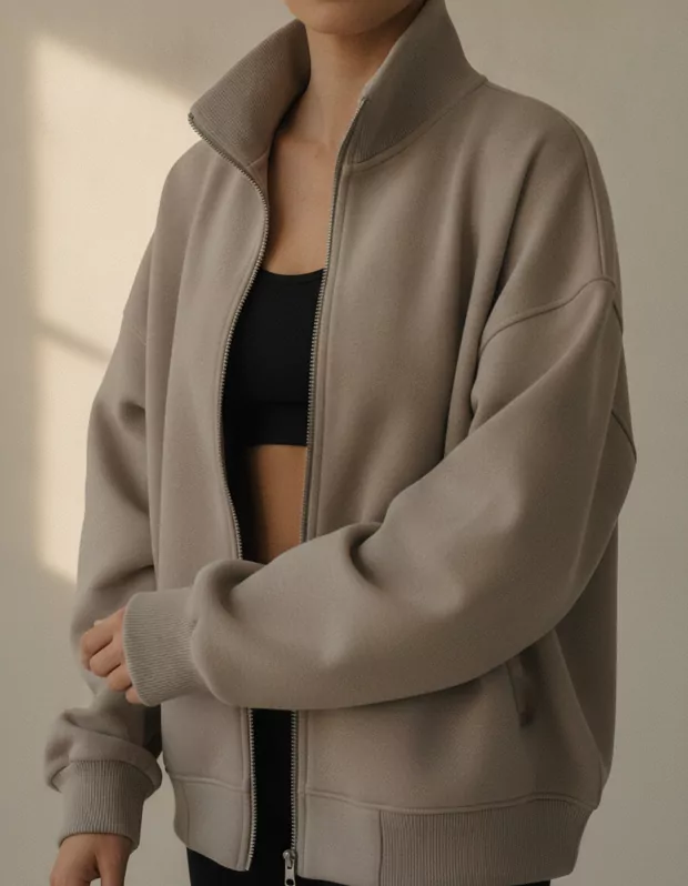 Close detail of a warm stone grey zip-through jacket
